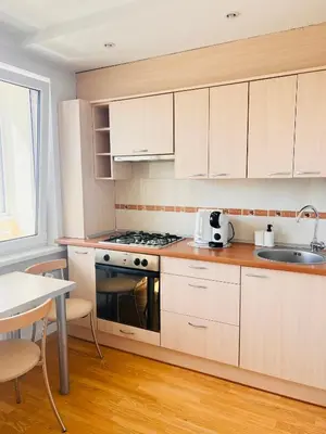 a kitchen with white cabinets and a sink and a stove at Butas Trakuose su vaizdu į ežerus-Lake view apartment in Trakai in Trakai