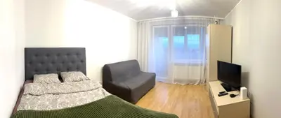 a bedroom with a bed and a chair and a television at Butas Trakuose su vaizdu į ežerus-Lake view apartment in Trakai in Trakai