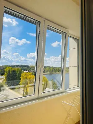 three windows in a room with a view of a river at Butas Trakuose su vaizdu į ežerus-Lake view apartment in Trakai in Trakai