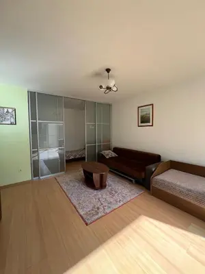 a living room with a bed and a couch at Cozy Maumedziu apartment in Vilnius
