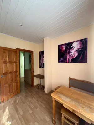 a room with a wooden table and a painting on the wall at Cozy Maumedziu apartment in Vilnius