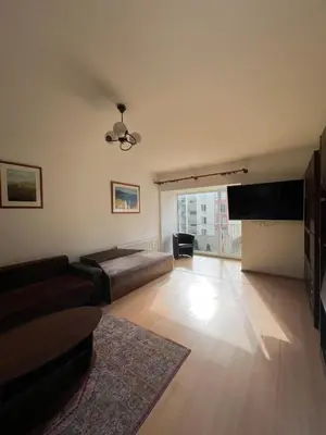 a living room with a couch and a flat screen tv at Cozy Maumedziu apartment in Vilnius