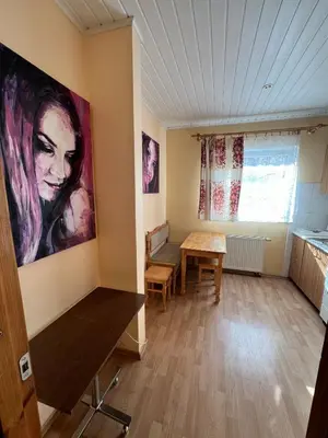 a room with a table and a painting on the wall at Cozy Maumedziu apartment in Vilnius