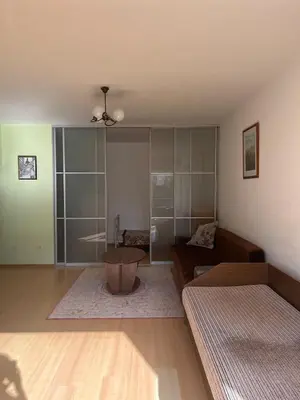 a living room with a couch and a table at Cozy Maumedziu apartment in Vilnius
