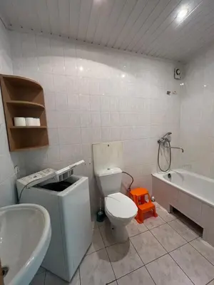 a bathroom with a toilet and a tub and a sink at Cozy Maumedziu apartment in Vilnius
