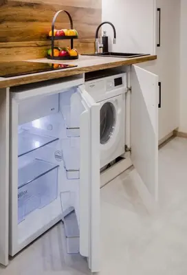 a kitchen with a washer and dryer under a counter at Green Apartment in Vilnius
