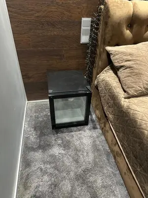 a nightstand sitting next to a bed in a room at B&M Romantic room Self check-in in Vilnius