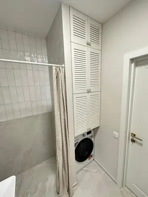 a bathroom with a shower and a washing machine at Cozy City Center Apartment in Kaunas