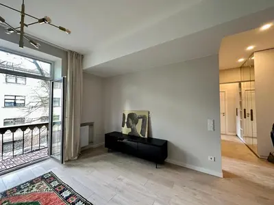 an empty living room with a large window at Cozy City Center Apartment in Kaunas