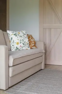 a couch with a pillow on it in a room at Rasota Pieva Dewy Meadow