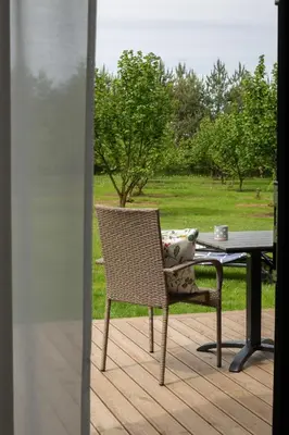 a table and a chair sitting on a patio at Rasota Pieva Dewy Meadow