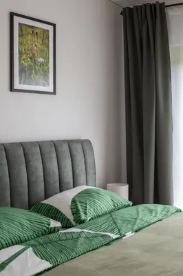 a bedroom with a bed with green pillows on it at Rasota Pieva Dewy Meadow