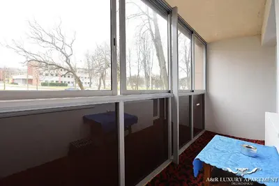 a room with a table and a large window at Luxury apartment Vytauto 16 in Druskininkai