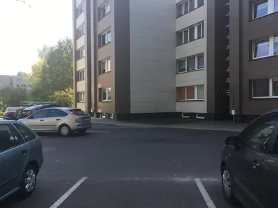 a parking lot with cars parked in front of a building at Luxury apartment Vytauto 16 in Druskininkai