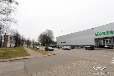 a parking lot with cars parked in front of a store at Luxury apartment Vytauto 16 in Druskininkai