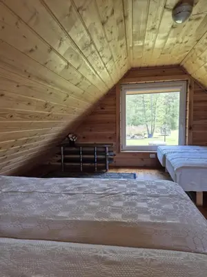 a room with two beds and a window at Sodyba LAIMĖS SLĖNIS in Kapčiamiestis