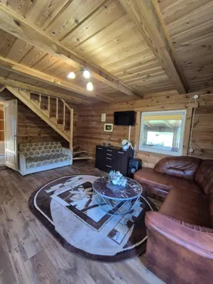 a living room with a couch and a table at Sodyba LAIMĖS SLĖNIS in Kapčiamiestis