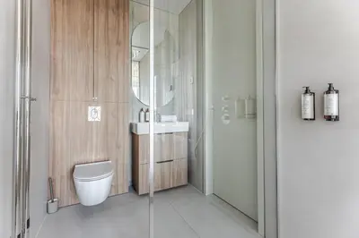 a bathroom with a toilet and a sink and a mirror at Luxury Honey Moon Apartments with Free Underground Parking in Kaunas