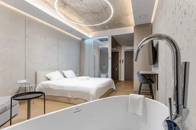 a bedroom with a bed and a tub in a room at Luxury Honey Moon Apartments with Free Underground Parking in Kaunas