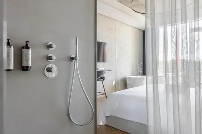 a white bathroom with a shower and a bed at Luxury Honey Moon Apartments with Free Underground Parking in Kaunas