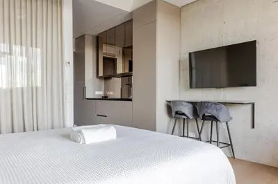 a bedroom with a bed and two stools and a tv at Luxury Honey Moon Apartments with Free Underground Parking in Kaunas
