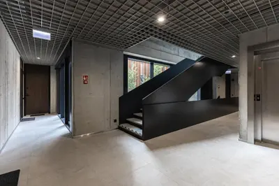 a black staircase in a building with a window at Luxury Honey Moon Apartments with Free Underground Parking in Kaunas