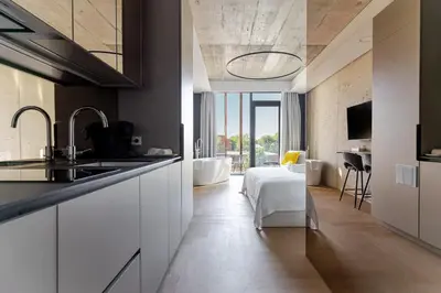a kitchen with white cabinets and a bathroom with a tub at Luxury Honey Moon Apartments with Free Underground Parking in Kaunas