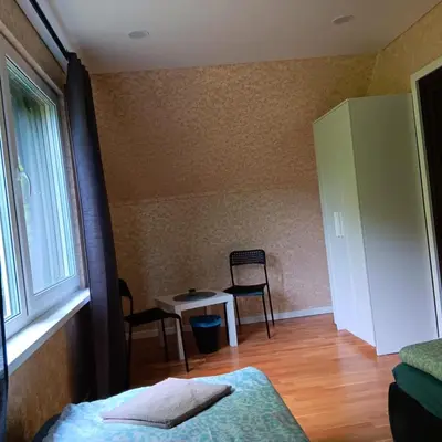 a bedroom with a bed and a table and chairs at Valva vila in Luokesos Sen
