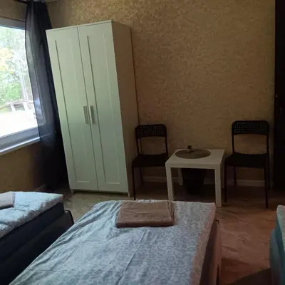 a bedroom with a bed and a cabinet and a table at Valva vila in Luokesos Sen