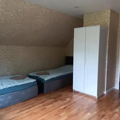a bedroom with two beds and a white cabinet at Valva vila in Luokesos Sen