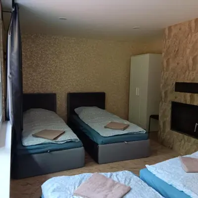 a room with two beds and a fireplace at Valva vila in Luokesos Sen