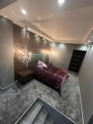 a bedroom with a bed and a chandelier at B&M Mini jecuzzi Lovers room Self check-in in Vilnius