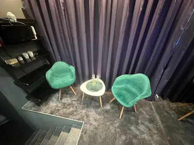 two green chairs and a table in front of a curtain at B&M Mini jecuzzi Lovers room Self check-in in Vilnius