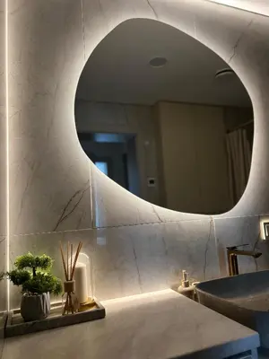 a bathroom with a round mirror and a sink at Apartamentai pirmame aukšte, miesto centre in Vilkaviškis