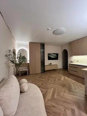 a living room with a couch and a kitchen at Apartamentai pirmame aukšte, miesto centre in Vilkaviškis