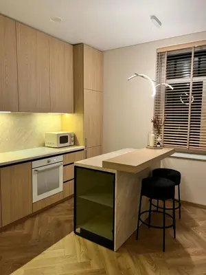 a kitchen with a counter and a table with a chair at Apartamentai pirmame aukšte, miesto centre in Vilkaviškis