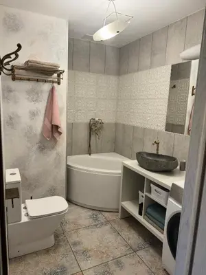 a bathroom with a tub and a toilet and a sink at Cozy Apartment in Vilnius Paupys in Vilnius