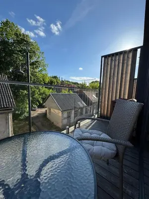 a balcony with a glass table and chairs on a deck at Cozy Apartment in Vilnius Paupys in Vilnius
