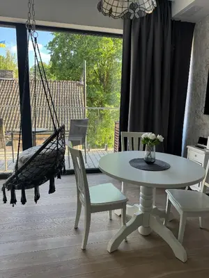 a room with a swing and a table and chairs at Cozy Apartment in Vilnius Paupys in Vilnius