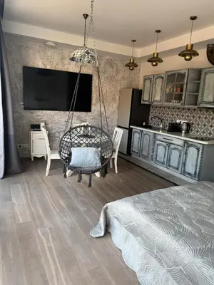 a room with a bed and a tv and a kitchen at Cozy Apartment in Vilnius Paupys in Vilnius