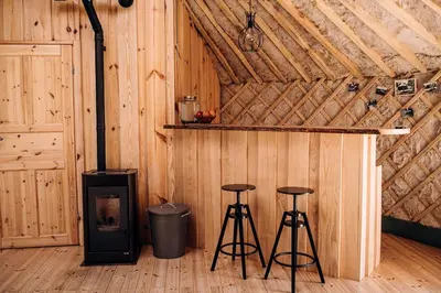 a room with two bar stools and a stove at Intimate Peaceful Yurt Surrounded by Nature in Lithuania in Jundeliškės