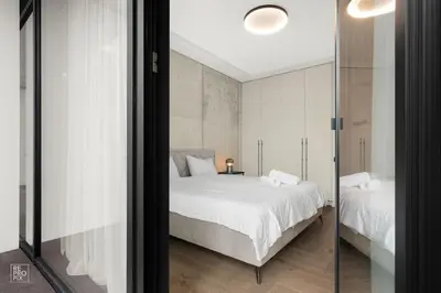 a bedroom with a white bed and a glass door at Comfortable 2 BD Apartment by Domvia in Kaunas