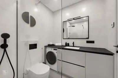 a bathroom with a washing machine and a mirror at Comfortable 2 BD Apartment by Domvia in Kaunas