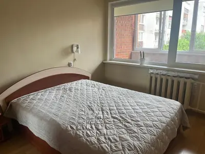 a bedroom with a bed and a window at Butas prie tvenkinio in Varėna