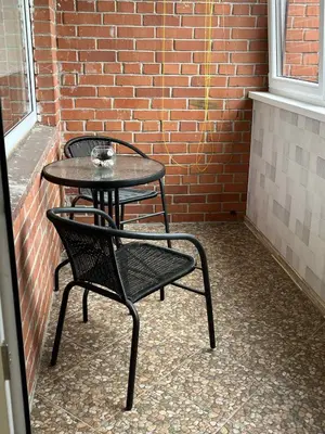a table and chairs sitting next to a brick wall at Butas prie tvenkinio in Varėna