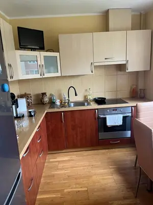 a kitchen with wooden cabinets and a sink at Butas prie tvenkinio in Varėna