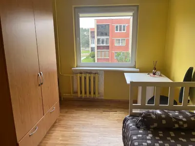 a bedroom with a bed and a window and a desk at Butas prie tvenkinio in Varėna