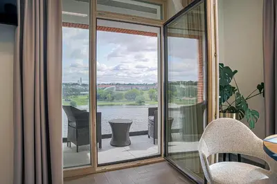 a screened in porch with a view of the water at River View Apartment with free parking in Kaunas