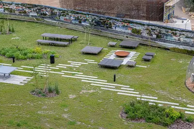 a park with benches and picnic tables in the grass at River View Apartment with free parking in Kaunas