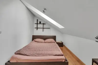 a bedroom with a bed in a white room at Vilnius Old Town Amber Penthouse in Vilnius
